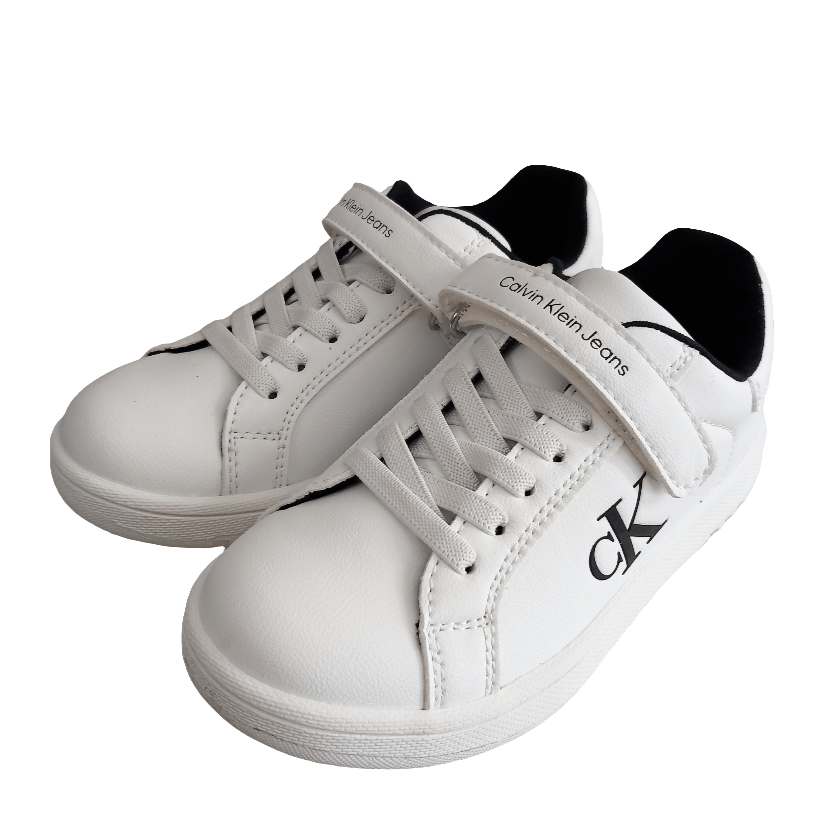 Sneakers bianche bambino con chiusura a strappo e lacci, logo CK laterale visibile.