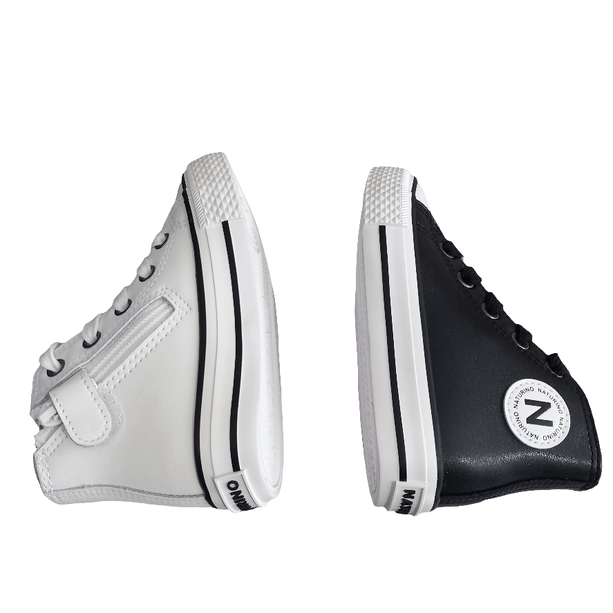 Sneakers bambino in pelle, una bianca e una nera, su sfondo bianco, stile casual